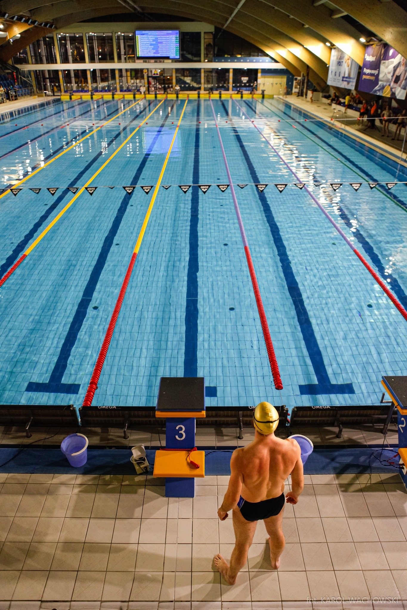 Pływak przy słupku startowym na basenie 50 m